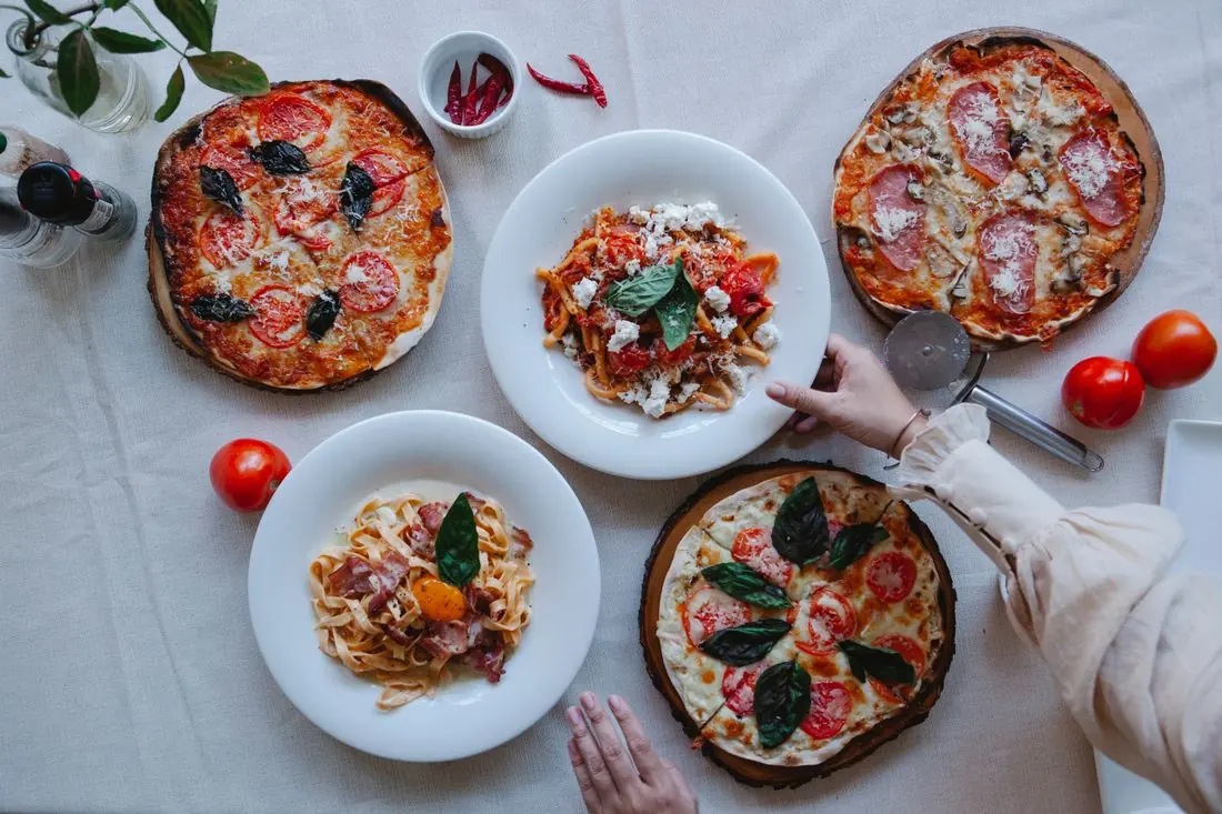 Mesa com pizzas e massas