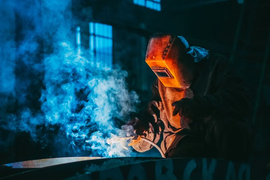 Soldador trabalhando com máscara de proteção