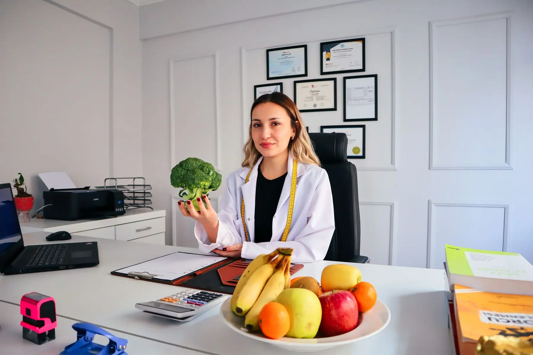Nutricionista em consultório segurando um brócolis