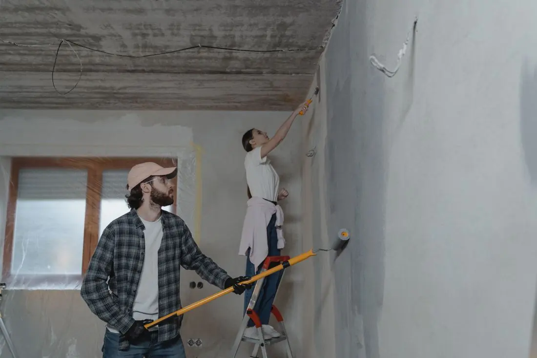 Casal pintando a parede da sala