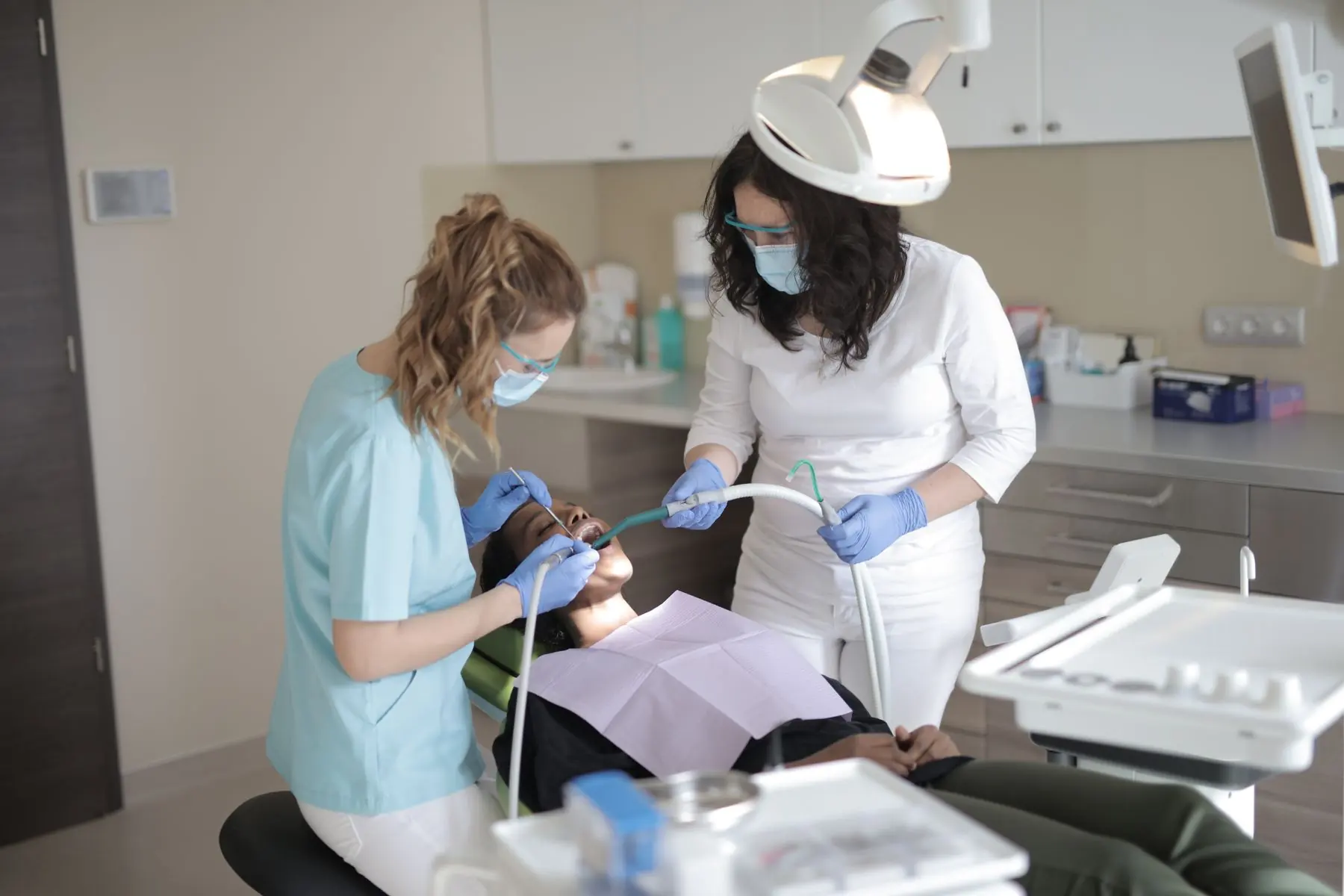 Dentistas atendendo paciente em consultório moderno