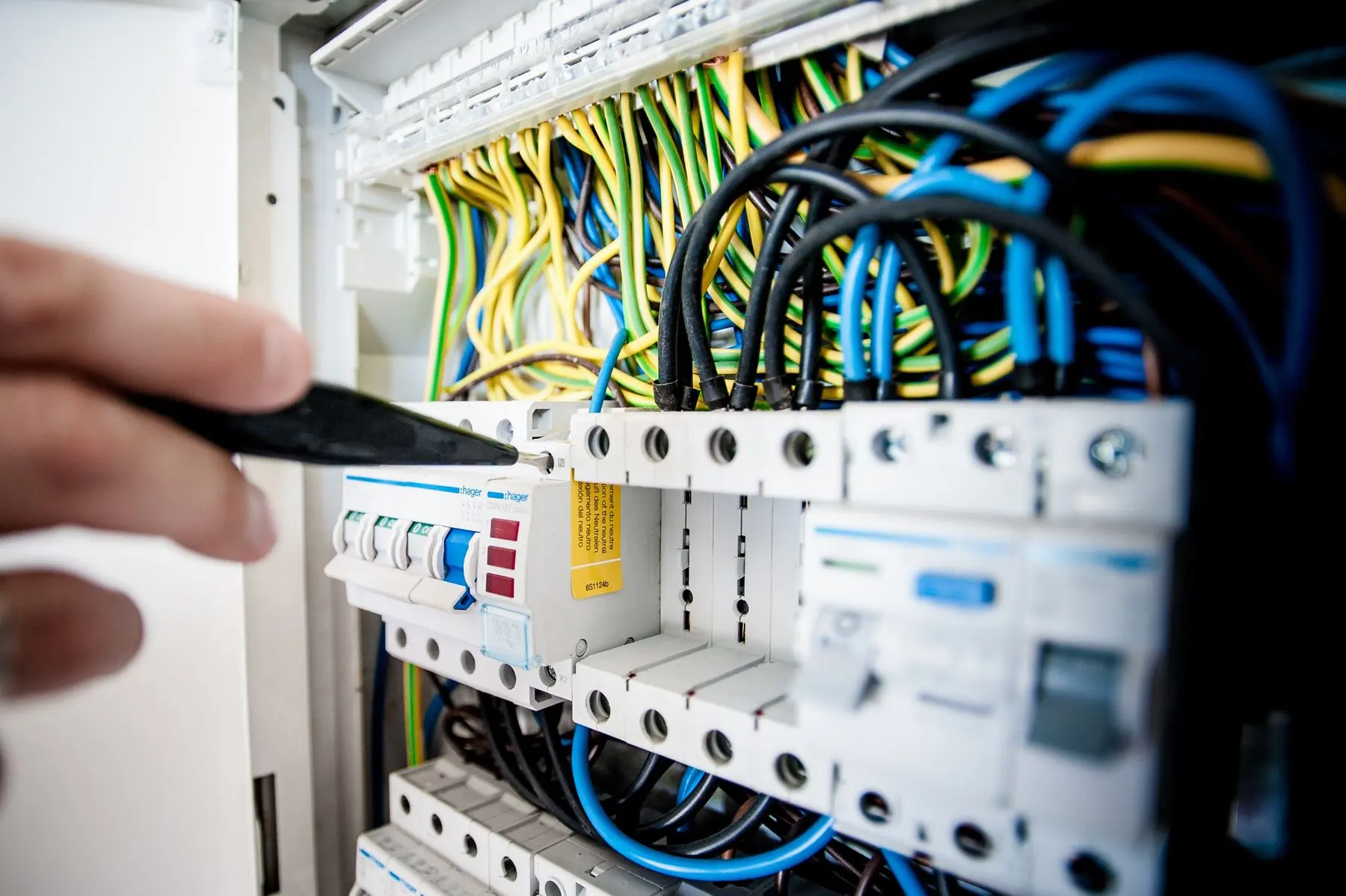 Eletricista trabalhando em quadro de disjuntores