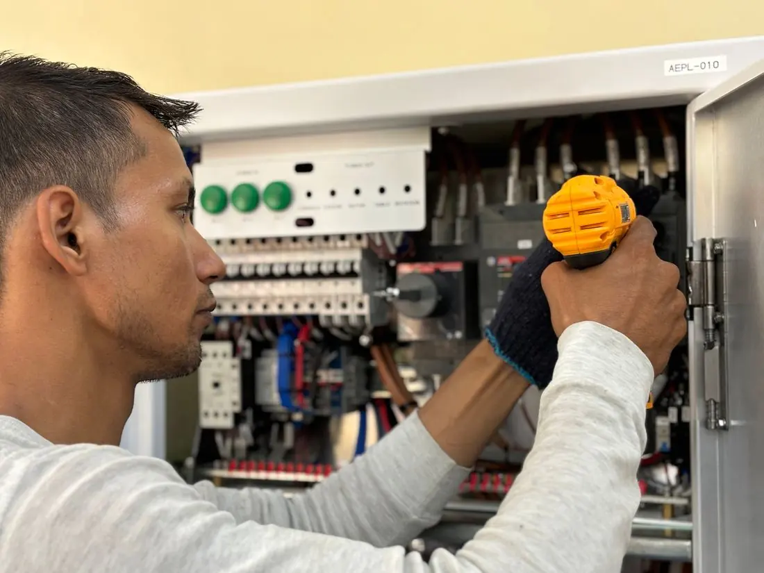 Eletricista medindo a tensão no quadro